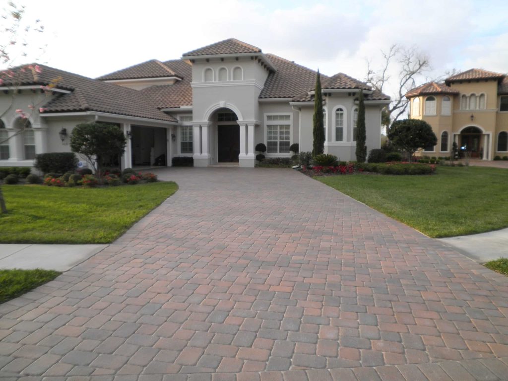 The same driveway after sealing, warm terracotta with the pattern visible