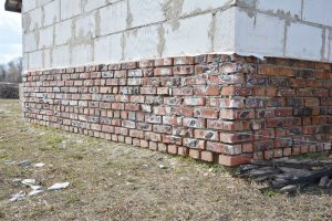 Brick foundation course beneath a white block wall