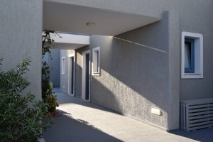 Covered concrete walkway along a modern grey building