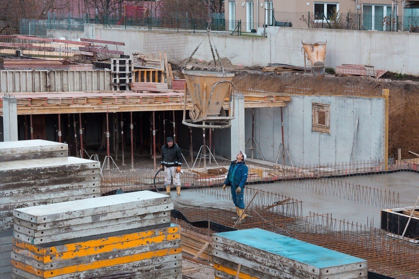 Multi-storey concrete building under construction, with formwork and stacked materials
