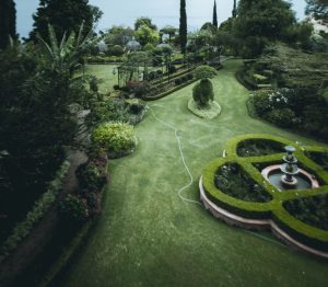 Formal garden from above, with clipped hedges, a circular fountain bed and lawn