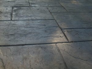 Large-format grey textured concrete paving slabs