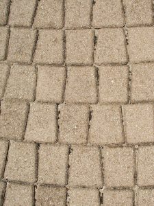 Buff paver setts seen from above, joints filled with sand