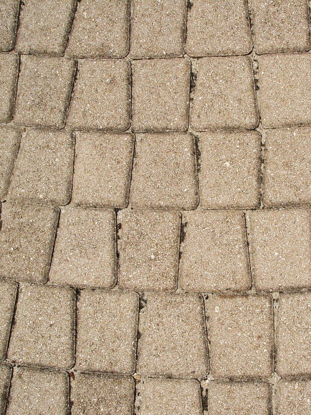 Buff paver setts seen from above, joints filled with sand