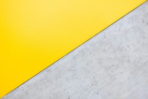 Plain grey concrete panel meeting a bright yellow panel on the diagonal