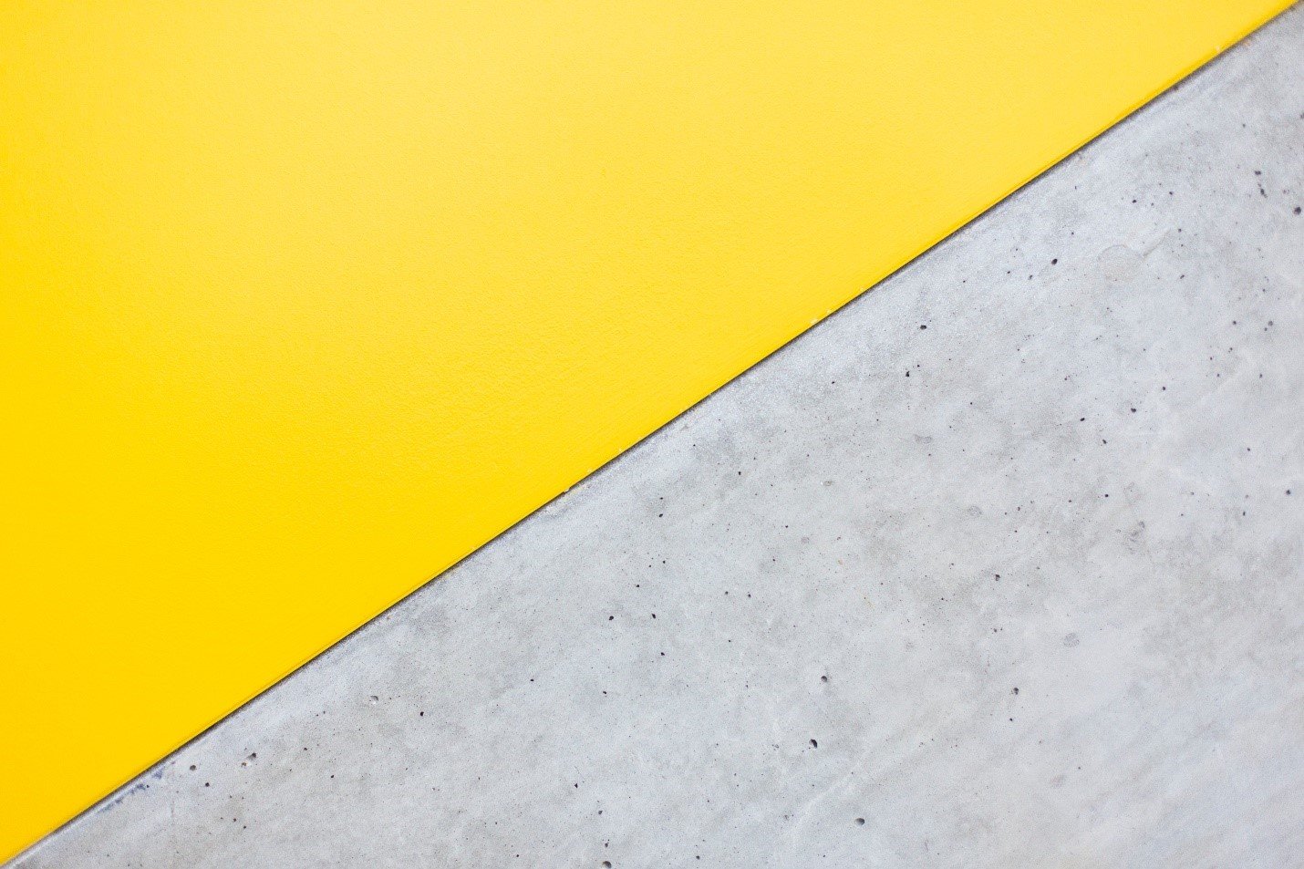 Plain grey concrete panel meeting a bright yellow panel on the diagonal