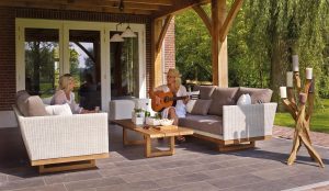 People seated on white sofas in a covered outdoor lounge under a timber pergola