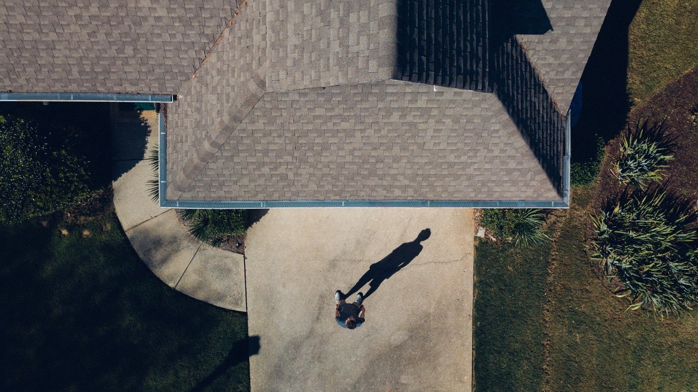 Aerial view of a house roof, driveway and swimming pool