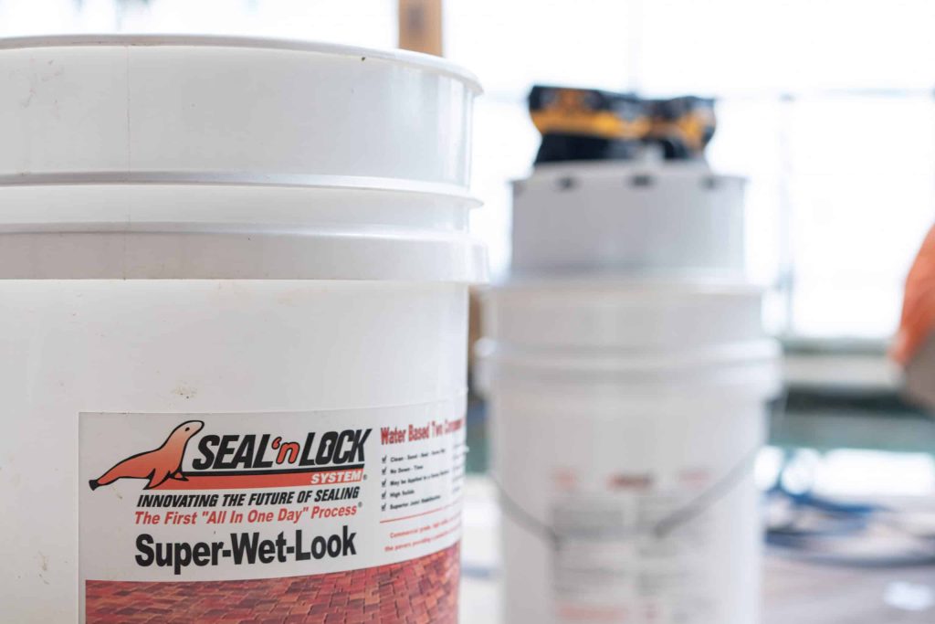 A Seal 'n Lock pail on a job site, the label reading The First All In One Day Process