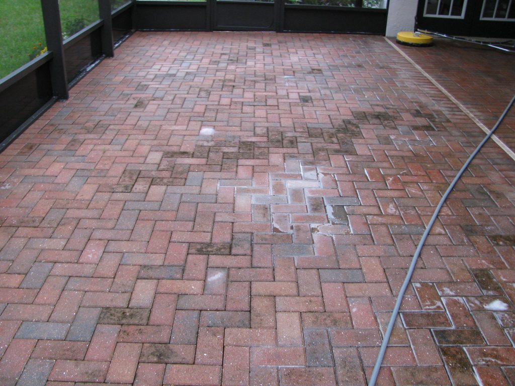 Red brick pool deck, wet and stained, hose still on the surface