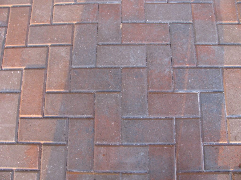 Red brick pavers in running bond, dulled by dirt
