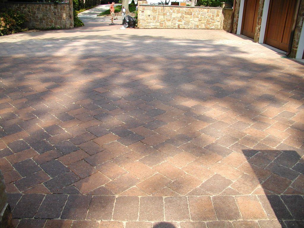 Sealed paver driveway running up to a stone house