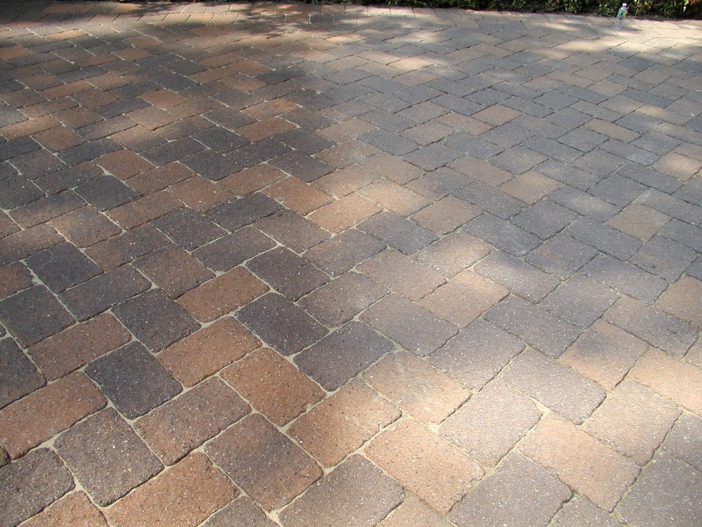 Wide paver driveway in dappled shade after sealing