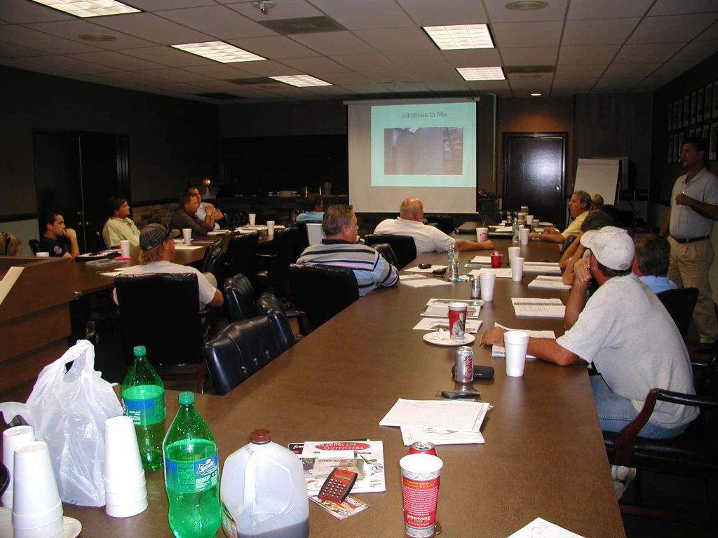 Contractors in a classroom session on mixing additives into sealer
